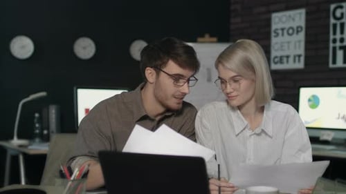 Young Business Man and Woman Working Together Front Laptop in Dark Office