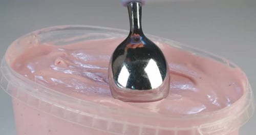 Close up slow motion of scooping of strawberry ice cream