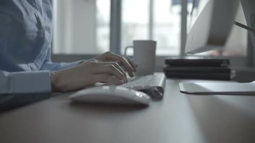 Hands Typing on Keyboard in Office Setting