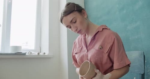 Young Woman Shaping Clay Bowl in Studio