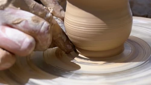 Potters Hände arbeiten mit Ton auf einer Töpferscheibe