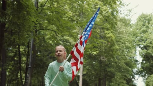 Girl Runs With American Flag in Sunny Park
