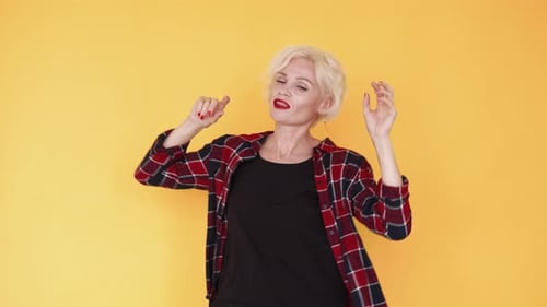 Woman Dancing and Smiling on Yellow Background