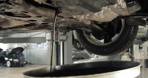 Stream Of The Old Used Engine Oil From A Car