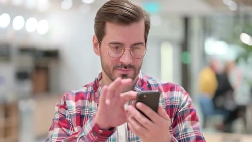 Attractive Male Designer Using Smartphone