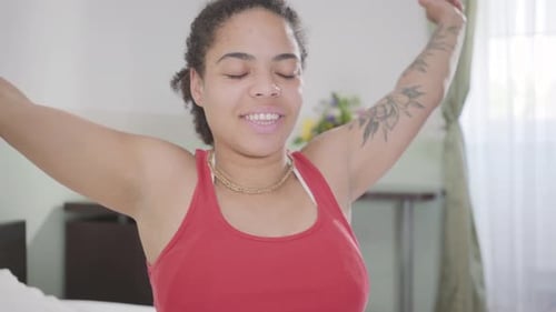 Woman Stretching in Sunny Bedroom