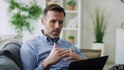 Man Talking on Laptop Computer From Couch