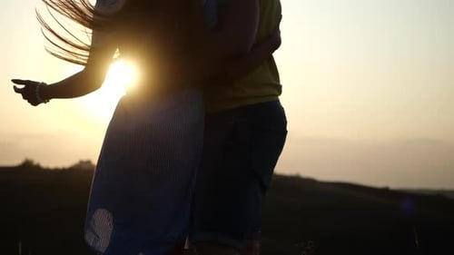 Bottom Up View of Happy Young Couple in Love Cuddling in Field, Enjoying Beautiful Romantic Evening