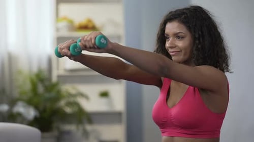 Woman Exercises With Dumbbells at Home
