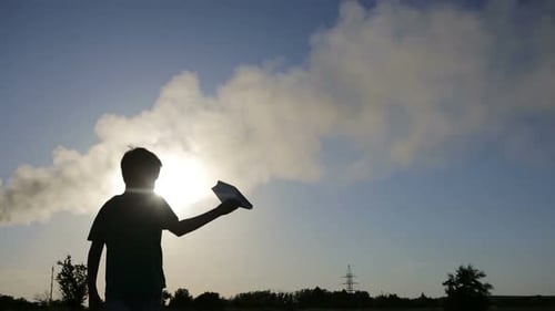 Boy Throws Paper Airplane Into Blue Sky