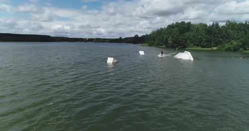 Wakeboarding in a City Reservoir, the Sportsman Surfs on the Water, Ride on a Wakeboarding Board and