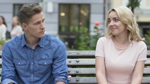Affectionate Couple Smiling and Kissing on Park Bench