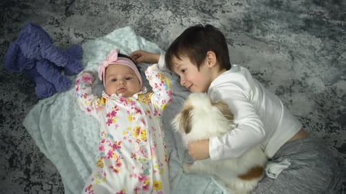 Baby Girl and Boy Cuddling Rabbit