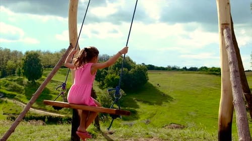 Girl on Swing Overlooking Green Meadow