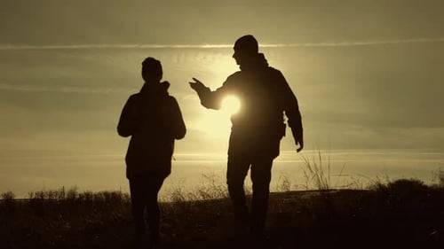 Happy Couple Man and Woman Tourist at Top of Mountain at Sunset Outdoors During a Hike