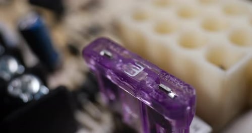 Close up of a small 3 amp fuse on a circuit board with other electronic components.