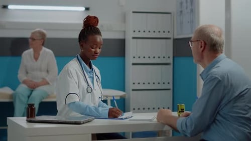Young Medic Explaining x Ray Result to Old Man at Desk