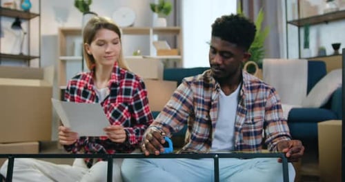 Hombre afroamericano midiendo un elemento metálico con cinta métrica