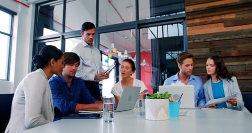 Diverse Team Collaborating at Table in Bright Office