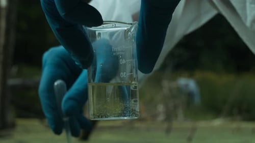 Process of Taking Water Analysis From Swamp Using Flask and Pipette Wearing Protective Suit and