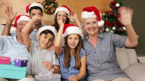 Família extensa feliz acenando para a câmera na época do Natal