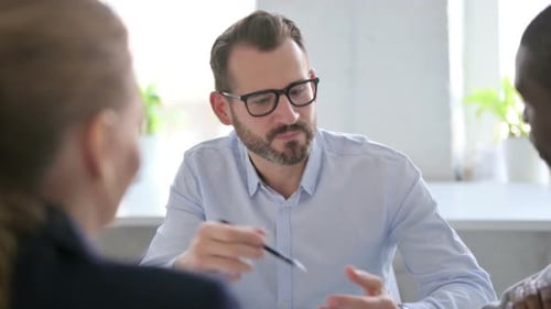Serious Businessman Talking to Colleagues in Office