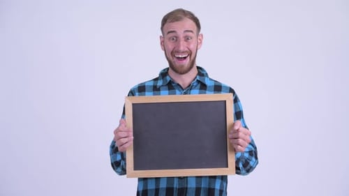 Man Holds Up a Blank Chalkboard, Smiles