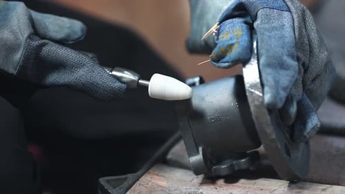 Worker Grinding Metal Component with Rotary Tool