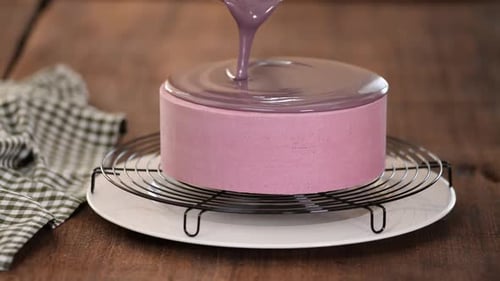 Close up of professional chef covering the glaze cake. Woman decorating cakes with mirrored glaze.