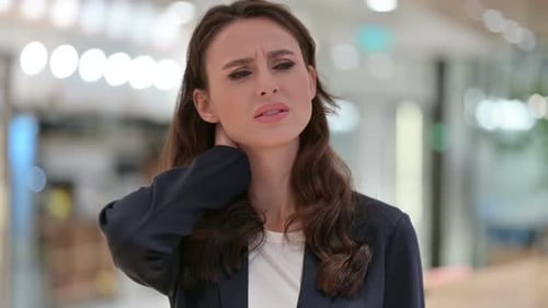 Young Woman Rubbing Painful Neck in Office
