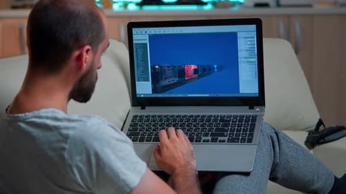 Man Works on Laptop with 3D Design Program