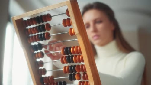 Young Adult Using Vintage Abacus for Calculations