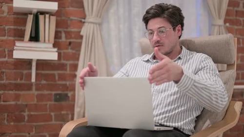 Adult Working on Laptop in Rocking Chair Indoors