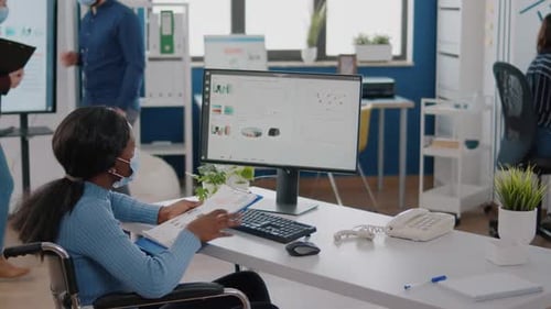 Black Woman with Disabilities and Protection Face Masks Working on Computer