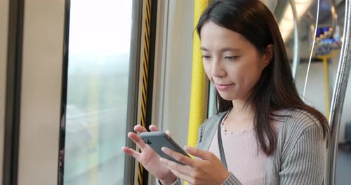 Femme regardant un téléphone portable à l'intérieur du compartiment du train