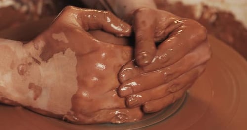 Hands Shaping Clay on Potter's Wheel Close Up