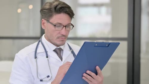 Doctor Writing on Clipboard in Office