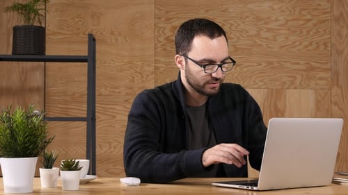 Man Working on Laptop in a Bright Office