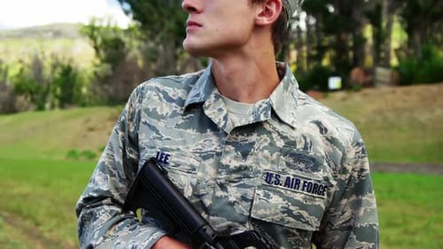 Young Soldier with Rifle Standing Guard Outdoors