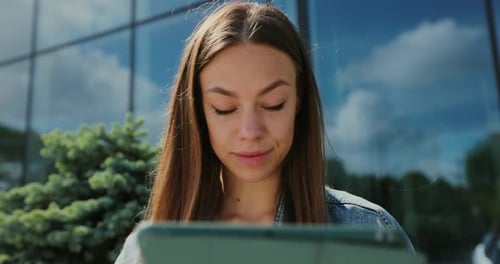 Woman Using Tablet Device Outdoors During Daytime