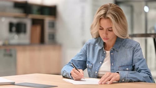 Woman Writing at Desk Indoors
