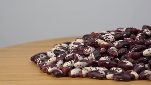 Pile of Colorful Speckled Beans on Wooden Surface