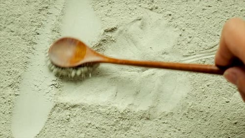 Wooden Spoon Drawing Lines in Green Clay Powder
