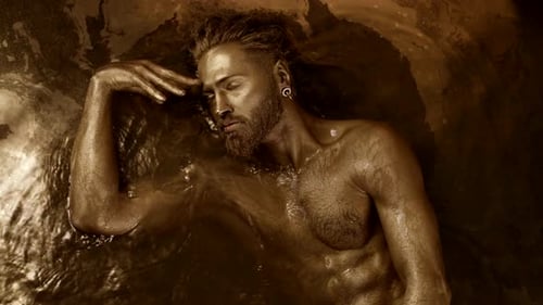 un homme pratique une danse extatique allongé dans l'eau en état de transe avec une peau dorée