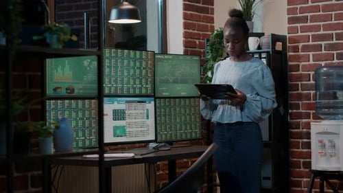Woman Analyzing Financial Data on Tablet in Office