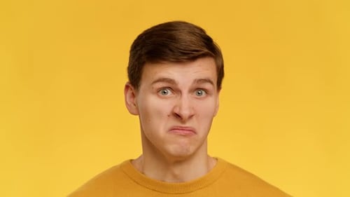 Angewiderter Mann verzieht das Gesicht und riecht schlechten Gestank, der auf gelbem Hintergrund steht