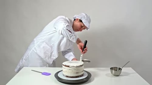 Woman Decorating a Cake with White Icing