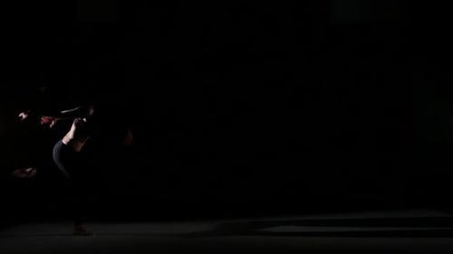Zeitgenössische Bewegungen von Mädchen im Schatten auf schwarzem Hintergrund, Zeitlupe