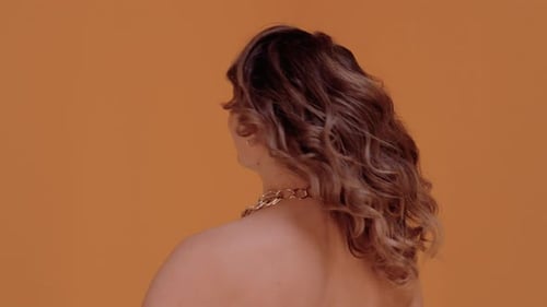 Woman Turns Head with Elegant Hairstyle and Makeup