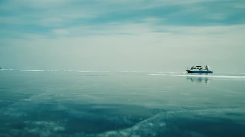 Hovercraft Rides on Frozen Lake Ice Among Snow Capped Mountains